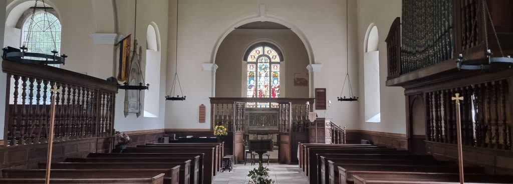 The inside of Farley All Saints church showing pews, organ and pulpit